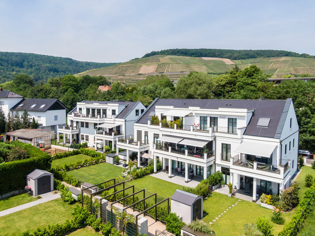 Moderne Mehrfamilienhäuser mit weißer Fassade und Balkonen und Aussicht auf umliegende Umgebung - professionelle Architekturfotografie
